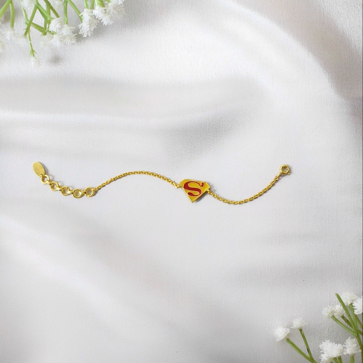 Gold bracelet with a red 'S' superman
